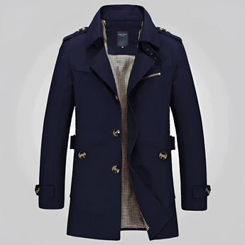 Men's beige double-breasted trench coat with epaulettes, featuring a classic collar and long sleeves, styled over a dress shirt for a formal and sophisticated look.