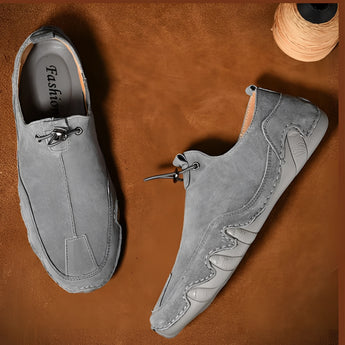 Men's gray suede slip-on loafers, size 47, featuring a casual and breathable design, displayed on a wooden surface with a focus on the shoe's texture and style.