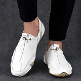 Men's beige suede slip-on loafers in a size 47, featuring a casual and breathable design with a white color variant, shown on a human leg.