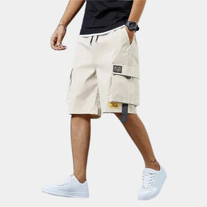Men's beige utility cargo shorts featuring a lightweight design and multiple pockets, perfect for summer wear, shown on a model highlighting the shorts' fit and style.