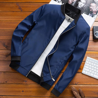 Men's blue bomber jacket in size 2XL featuring a sleek nylon material and durable zipper, displayed on a wooden surface.