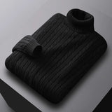 Men's black cable knit turtleneck sweater displayed on a wooden surface.