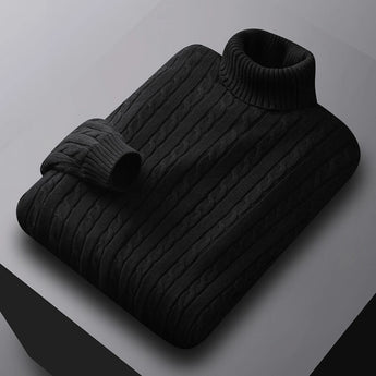 Men's black cable knit turtleneck sweater displayed on a wooden surface.