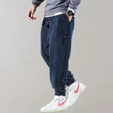 Men's black corduroy cargo pants with an ankle-tapered fit, designed in an urban style.