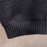Men's black crewneck sweater featuring ethnic pattern sleeves in a woven fabric style.