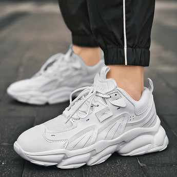 Men's black and white high-top sneakers displayed on a grassy surface, showcasing their stylish and breathable design with durable materials, ideal for walking and fashion-forward looks.