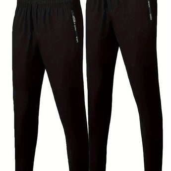 Men's black joggers, lightweight athletic pants with zippered pockets, showing waist and thigh fit.