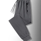 Men's black joggers featuring lightweight fabric and zippered pockets, designed for athletic wear.