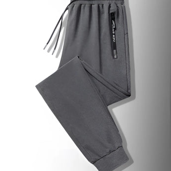 Men's black joggers featuring lightweight fabric and zippered pockets, designed for athletic wear.