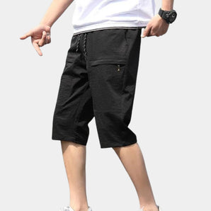 Men's black knee-length cargo shorts with multiple pockets and an adjustable waist, size 44.