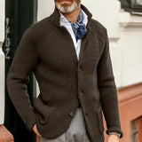 Men's black knit blazer modeled by a bearded man in a formal setting, showcasing the designer cardigan style with a focus on fashion and textile detail.