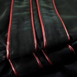 Men's black leather biker jacket with red piping, featuring a stylish collar and comfortable sleeves, designed for motorcycle enthusiasts.