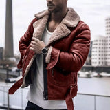Men wearing a black leather jacket with a shearling collar, styled with a cool and urban fashion vibe. The jacket's design includes prominent features such as sleeves and a stylish collar, paired with a red interior lining. The man is standing confidently, sporting eyewear and a beard, embodying a trendy look.