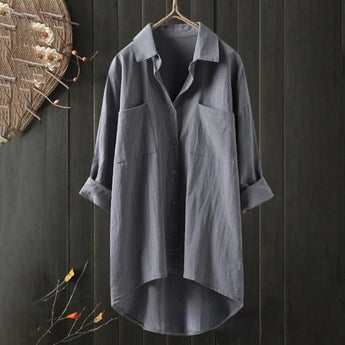 Men's gray linen shirt on a clothes hanger, featuring long sleeves, a collar, and a design suitable for formal or casual occasions.