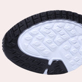 Men's black mesh running shoes featuring a lightweight, breathable design with a focus on comfort, set against a backdrop of an automotive tire and wheel assembly.