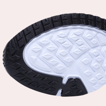 Men's black mesh running shoes featuring a lightweight, breathable design with a focus on comfort, set against a backdrop of an automotive tire and wheel assembly.