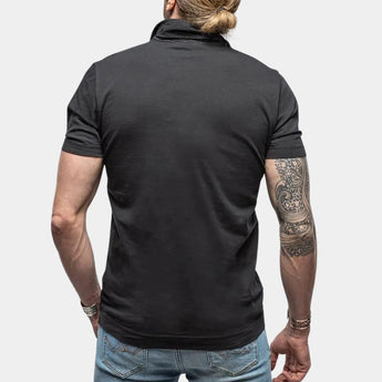 Men's black muscle-fit polo shirt made of athletic stretch fabric, featuring short sleeves and a fitted design that accentuates the waist and neck, worn with jeans.