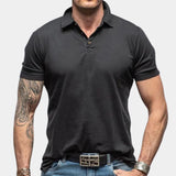 Men's black muscle-fit polo shirt made from athletic stretch fabric, featuring a short sleeve design and a classic collar, shown in size 2XL.