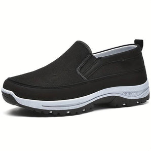 Men's black slip-on walking shoe with a lightweight and breathable design, featuring a cushioned sole and synthetic rubber material, suitable for outdoor activities and sportswear.