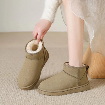 Men's black slip-on winter boots featuring a fleece lining, shown on a person standing on a floor. The boots are designed to be non-slip and durable, suitable for cold weather.