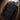 Men's black thermal water-resistant puffer jacket displayed in an indoor setting with tire elements around, highlighting its rugged and durable nature.