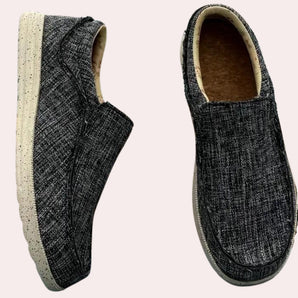Men's black tweed slip-on sneakers with a cushioned sole featuring a stylish pattern, designed for comfort and fashion.