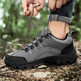 Men's gray waterproof hiking shoes with non-slip soles, designed for outdoor activities, shown on grass with a tree in the background.