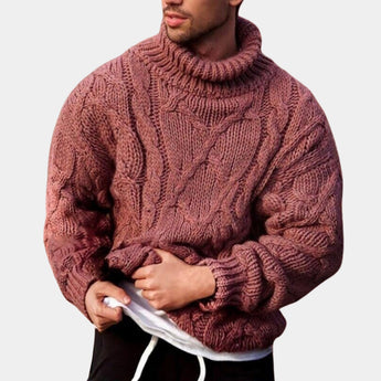 Men's black wool cable knit turtleneck sweater with a high collar, showcased on a model wearing headgear and a beard, highlighting the sweater's long sleeves and cozy winter fashion design.