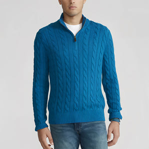 Men's blue cable knit zip-up sweater featuring ribbed trim, long sleeves, and a high neck, highlighting winter fashion style.