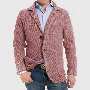 Men's blue knit blazer made of wool featuring a notch lapel, displayed on a hanger with a dress shirt underneath, showcasing its tailored sleeves and collar.
