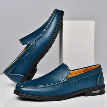 Men's blue leather loafers with a metal buckle, featuring a slip-on design and a sleek dress shoe style.