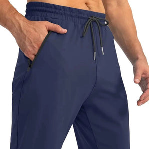 Men's blue quick-dry athletic shorts featuring zipper pockets, shown on a model highlighting the fit around the waist and leg area.