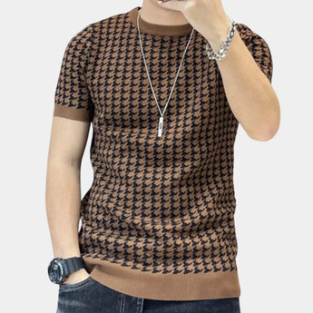 Brown houndstooth slim fit tee worn by a person, showcasing the upper body including arms, shoulders, and neck. The tee is designed with a stylish houndstooth pattern and is part of a designer fashion knit collection. The wearer appears to be of larger build, suggesting the 3XL size variant.