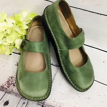 Men's brown suede slippers with an adjustable strap and non-slip sole, displayed on a green grassy surface, size 43.