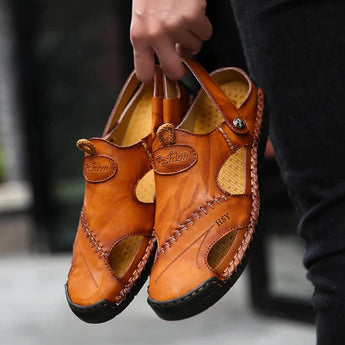 Men's casual brown leather sandals shown on a person's feet, highlighting their breathable and lightweight design.
