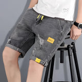 Men's Distressed Cuffed Denim Shorts in Light Wash, Gray, Size 5XL, modeled on a person showing the shorts from the waist down with a focus on the distressed details and cuffed hem.