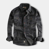 Men's durable military camo style jacket in green grey camouflage pattern, featuring a collared design with long sleeves, front buttons, and multiple pockets; size 3XL.