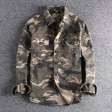 Men's military-style camouflage jacket with long sleeves, featuring a durable design suitable for tactical use. The jacket showcases a classic collar and a distinctive camo pattern, blending fashion design with the practical aesthetics of a uniform.