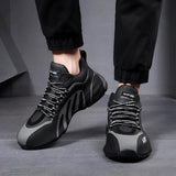 Men's grey futuristic design sneakers displayed on a human foot, showcasing urban athletic style and contemporary fashion trends.