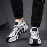Men's fashionable futuristic design sneakers in black and grey, styled for urban athletic wear, shown on a person's feet.
