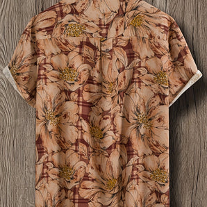 Men's floral print short sleeve shirt, tropical summer button-up with collar on a clothes hanger.