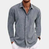 Men's gray chambray long sleeve shirt featuring a breathable cotton fabric, designed for workwear. The shirt includes a classic collar and button-down front, with attention to detail around the neck and elbow areas, offering both style and comfort in outerwear.