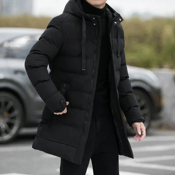 Men's black hooded insulated parka, long puffer winter coat with grey accents, worn by a person standing.