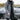 Men's grey hooded insulated parka, long puffer winter coat, displayed in size 4XL, featuring a hood and long sleeves against a background with a black vehicle and visible car tire.
