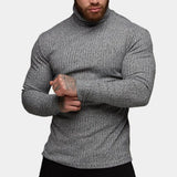 Men's grey knit turtleneck sweater with a fitted muscle fit design, showcasing long sleeves, a high collar, and a textured textile, worn by a bearded model.
