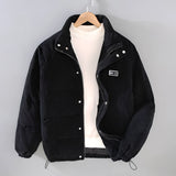 Men's grey quilted puffer jacket with corduroy patchwork, featuring a collar and button closure, shown in Nero color variant, size 2XL.