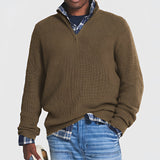 Men's grey ribbed half-zip sweater featuring a high collar and long sleeves, styled with denim jeans, ideal for fall and winter wear.