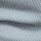 Men's grey ribbed knit crew neck sweater with striped pattern, featuring long sleeves and woolen texture, displayed against a denim background.