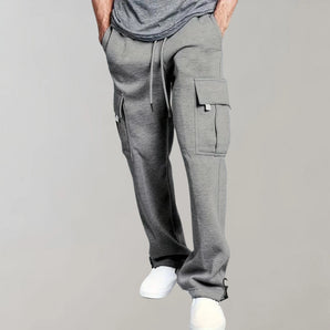 Men's grey slim fit cargo joggers featuring zipper pockets, showcasing a modern design with a focus on the waist, thigh, and knee areas.
