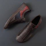Men's grey slip-on sneakers featuring red accents, showcasing a sleek and comfortable design ideal for casual wear.